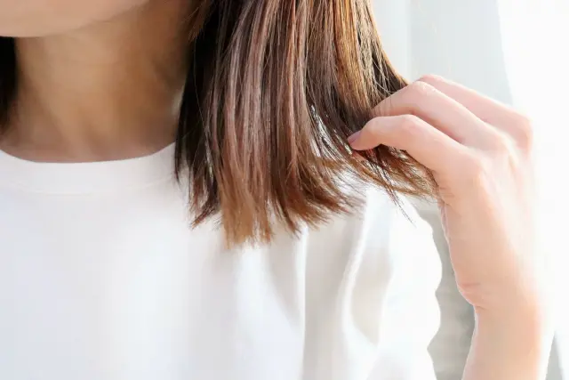 毛先を光にかざして枝毛の有無を確認する様子