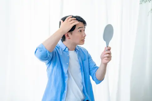 鏡を見る男性