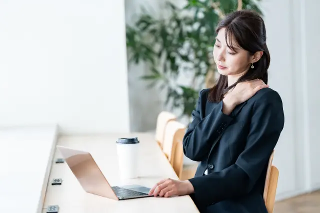 デスクワーク中の正しい姿勢を意識する女性