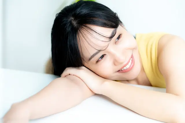顔を机につける女性