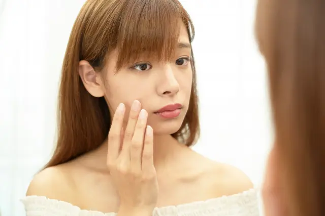 鏡で肌の状態を確認する人のイメージ