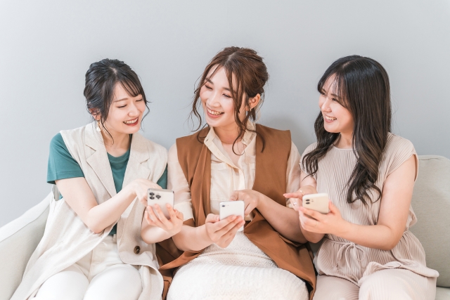 スマホを見せ合う女性たち