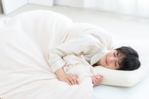 ベッドで寝る女性