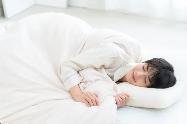 ベッドで寝る女性