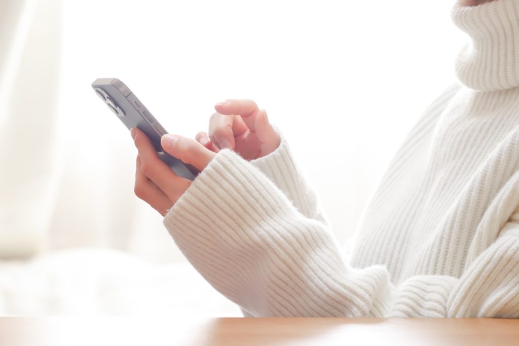 
スマホを触る女性の手元
