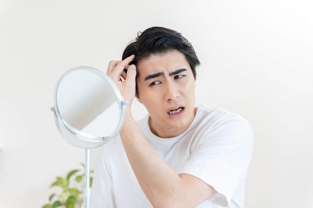 
髪の毛を気にする男性