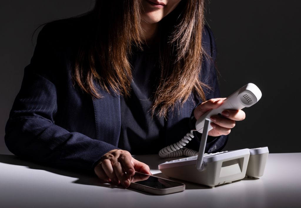 詐欺電話をかける女性