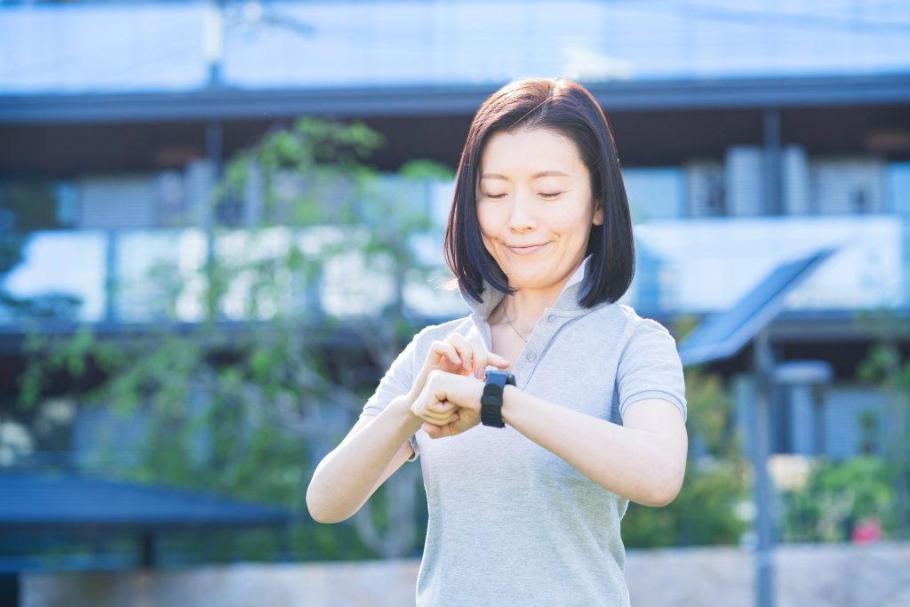 スマートウォッチを操作するミドル女性