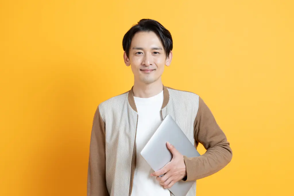 パソコンを持つ笑顔の日本人男性