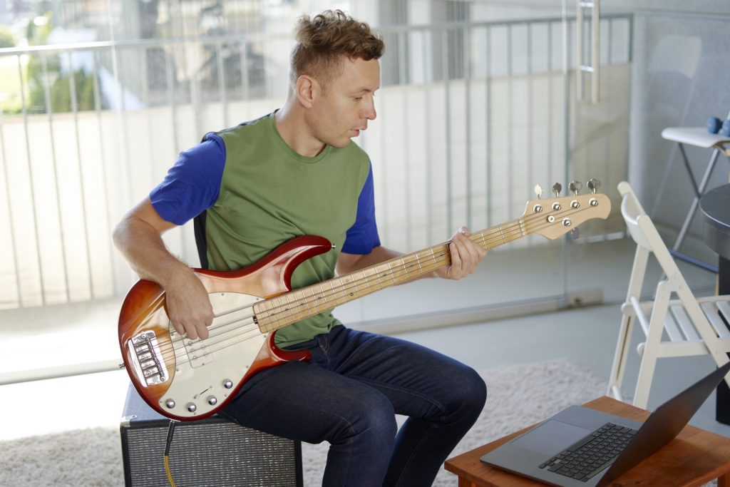 
部屋でエレキギターを弾く男性