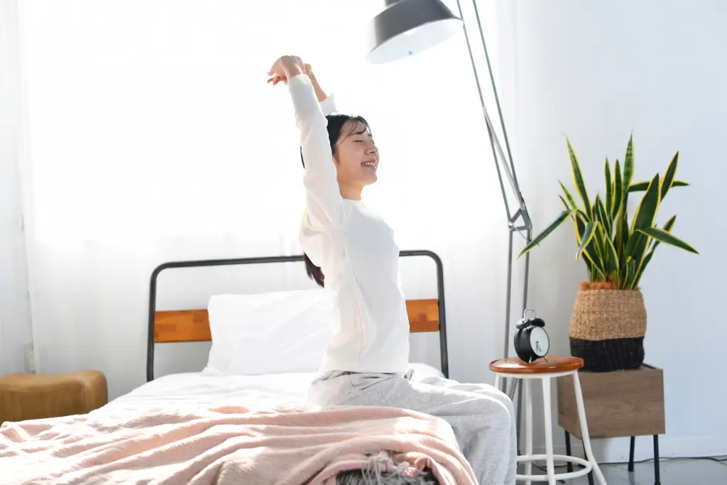 朝型タイプでベッドから起き上がる女性