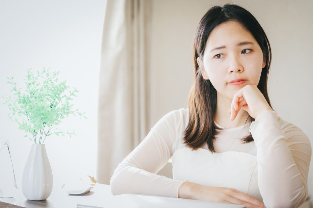自宅で悩んでいる女性