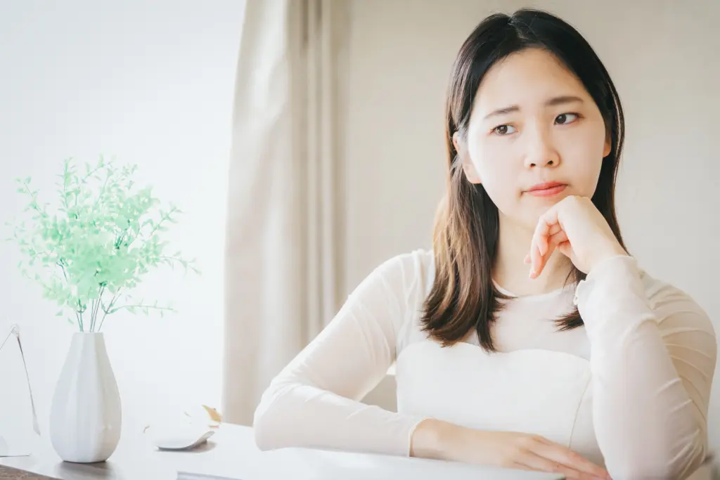 
自宅で悩んでいる女性
