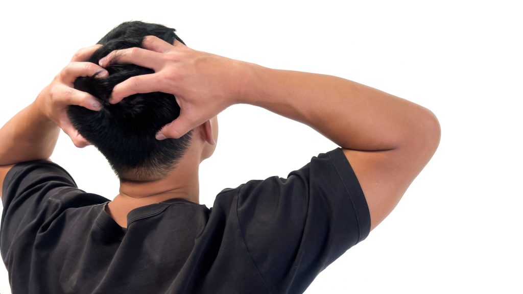 心配事や悩み事で頭を抱える男性の後ろ姿