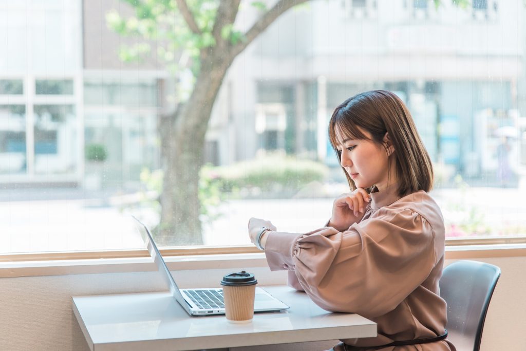 
腕時計を確認する日本人ビジネスウーマン