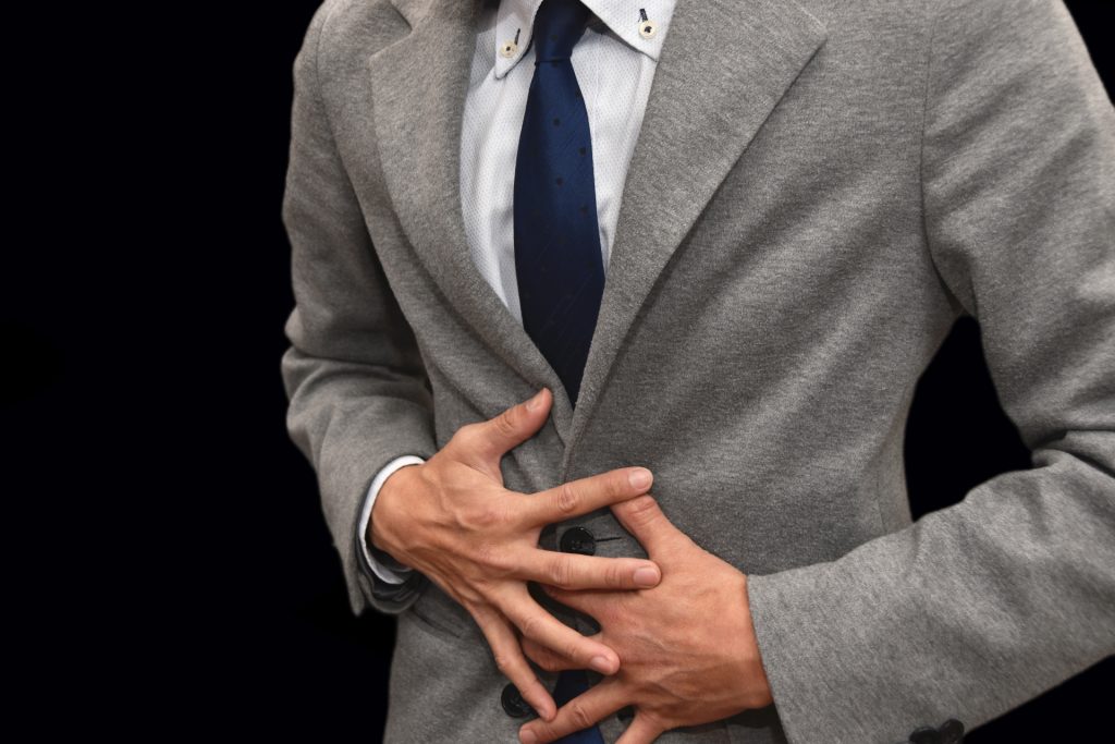 おなかを押さえる男性