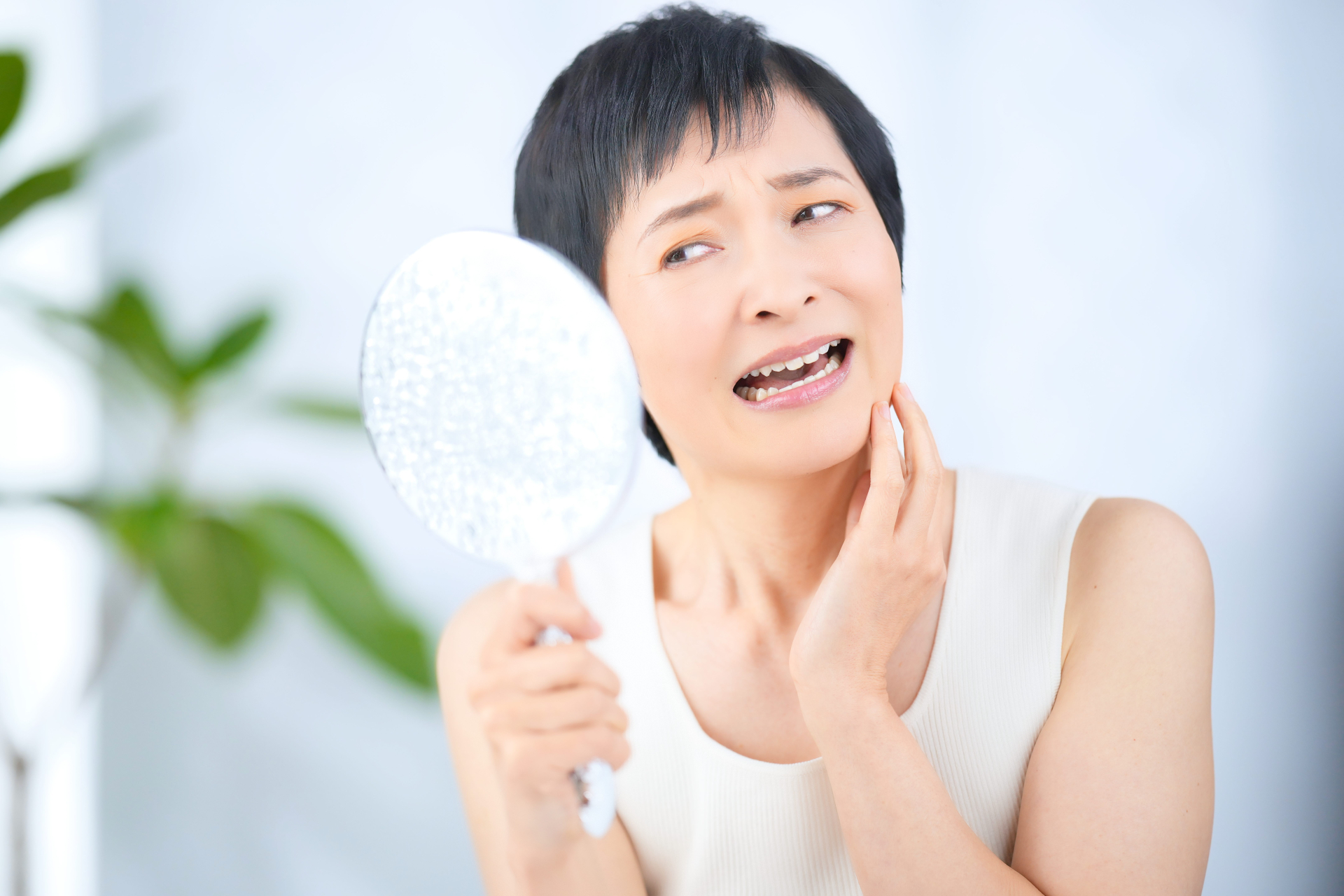 手鏡を見て肌のトラブルを気にしているショー