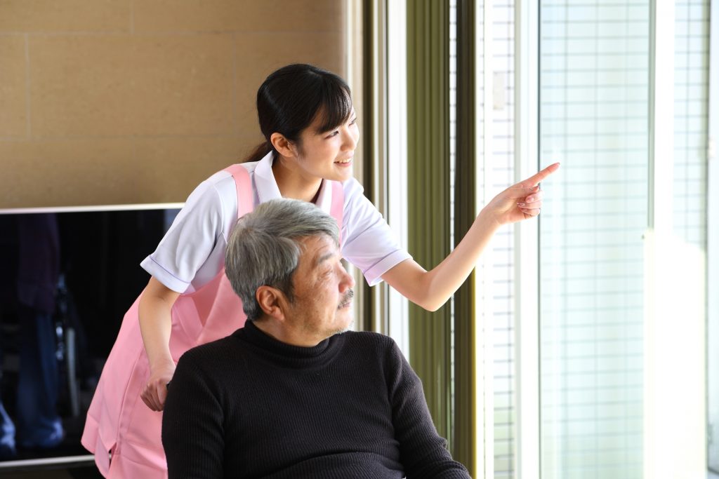 
車椅子に乗る高齢者男性と女性の介護士