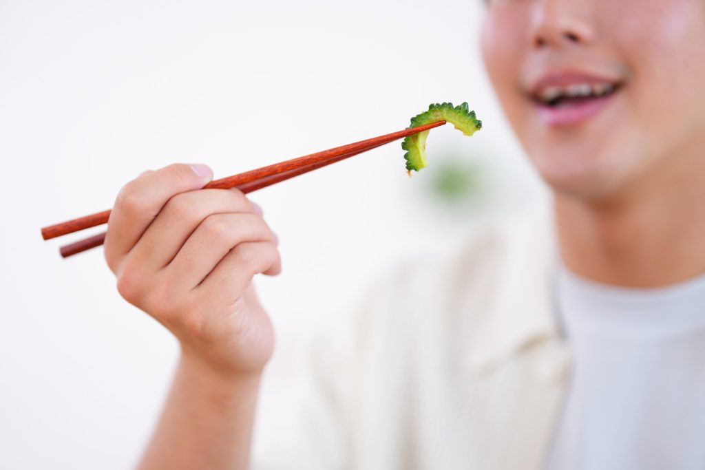 
ゴーヤを食べようとする人の口元