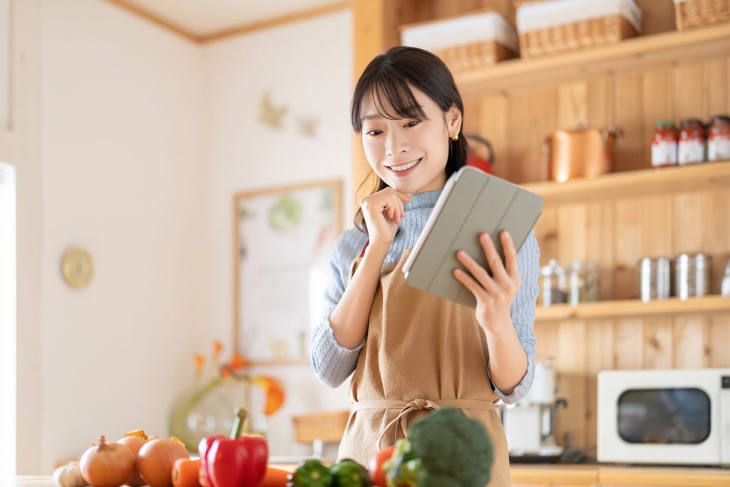 
キッチンでタブレットを使う笑顔の女性