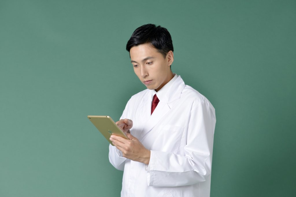 
iPadを操作する白衣を着た男性2