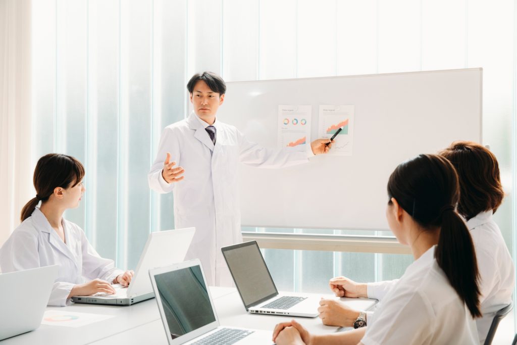 
会議する白衣姿の男女