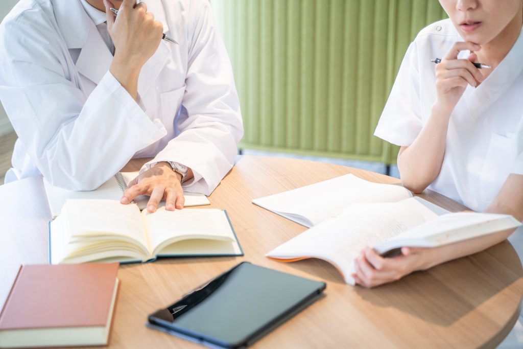 
勉強する看護師と医者の手元