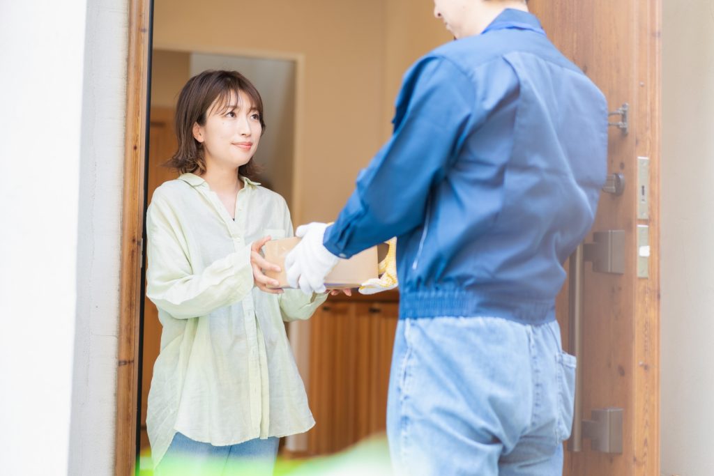 宅配便・デリバリーを受け取る若い女性