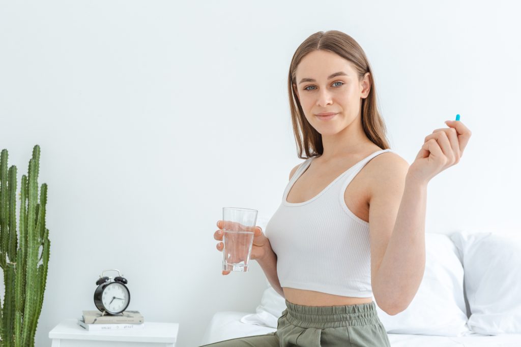 カプセル剤を持って振り向く女性