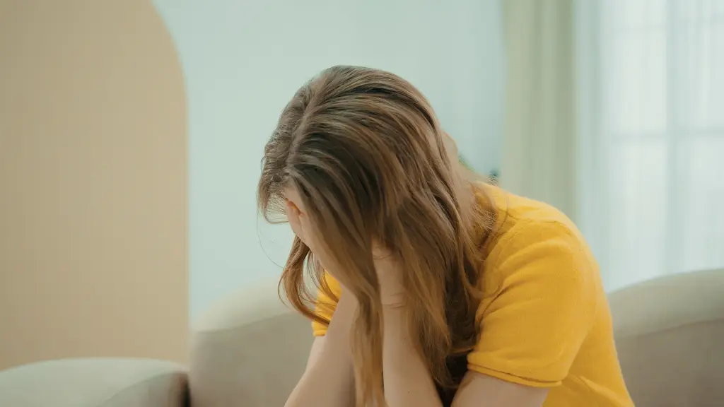 座って顔を覆って泣く女性