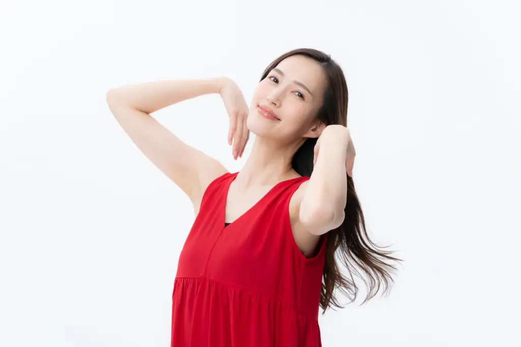ヘアケアをする白バックの若い女性