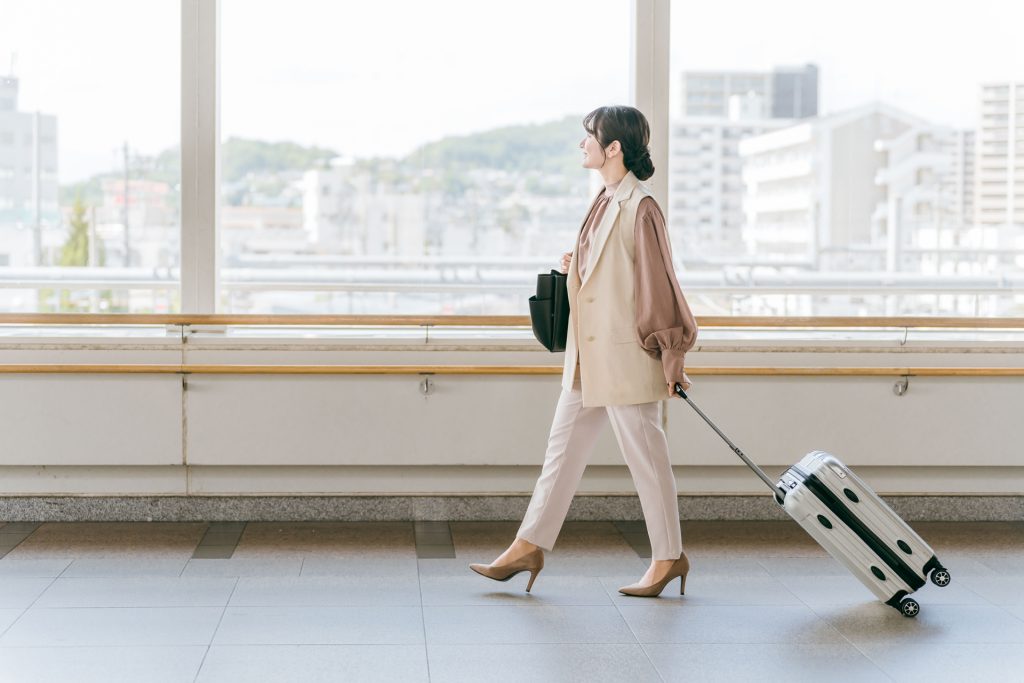 出張・転勤・旅行・人事異動をする女性