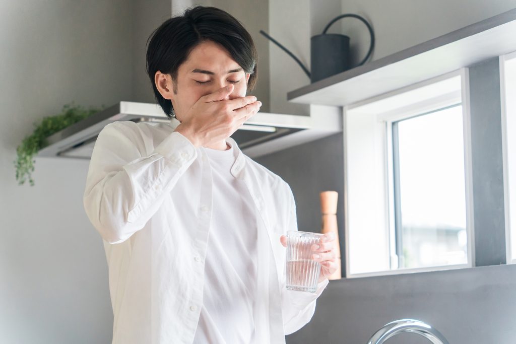 内服薬・サプリ・医薬品を飲む病気の男性