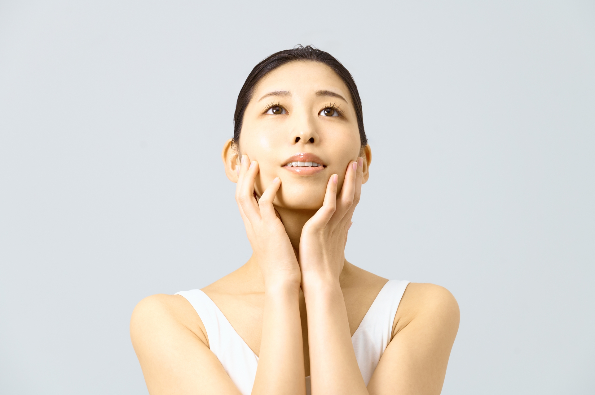 スキンケア　両手で顔を触る女性　美容