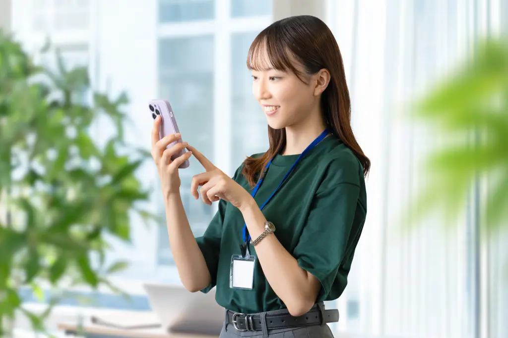 スマホを使う笑顔の女性・ビジネスウーマン