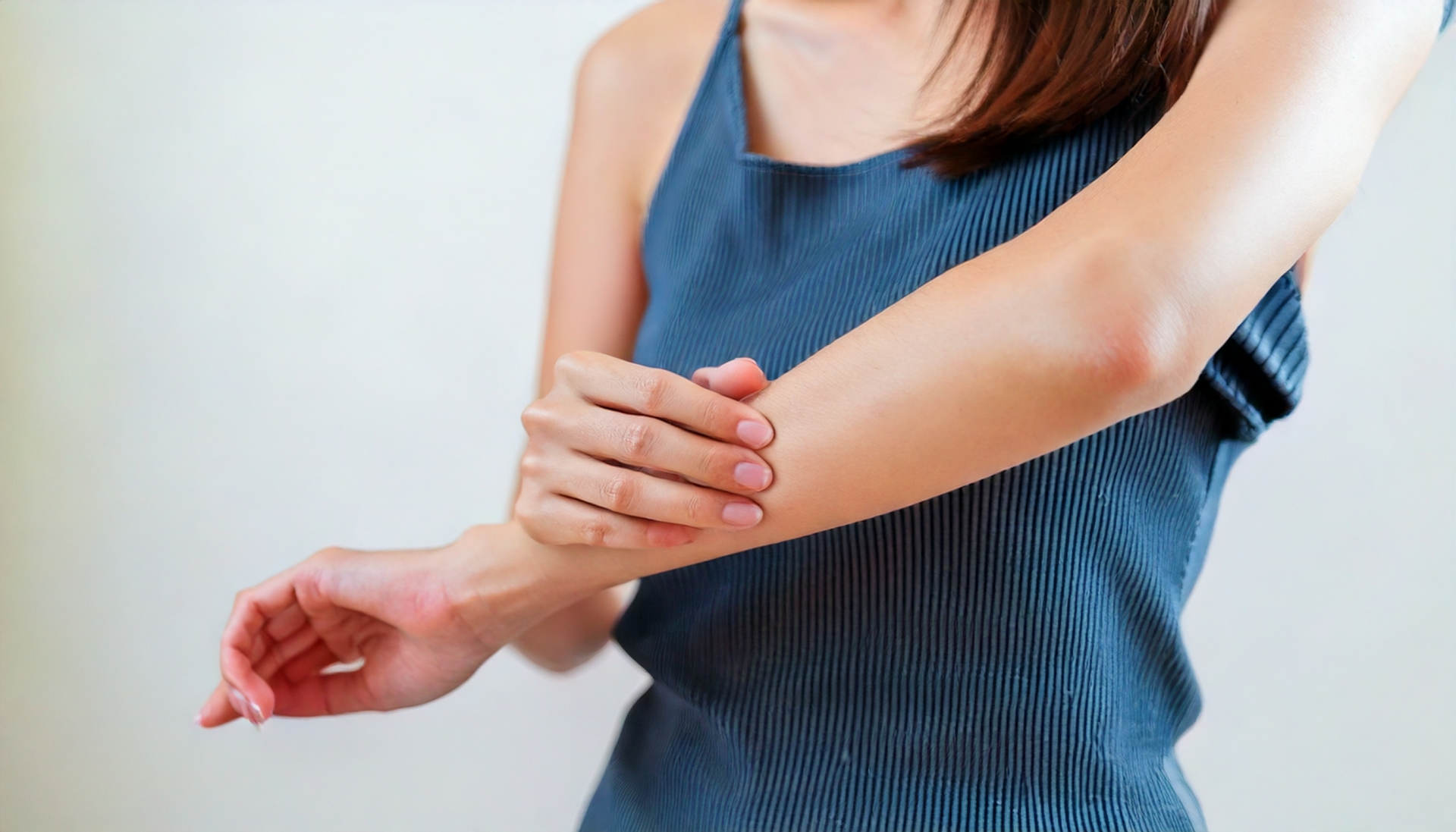 腕がかゆくてそれをかいている女性の手