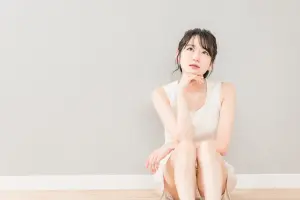 頬杖をついて考える・悩む女性