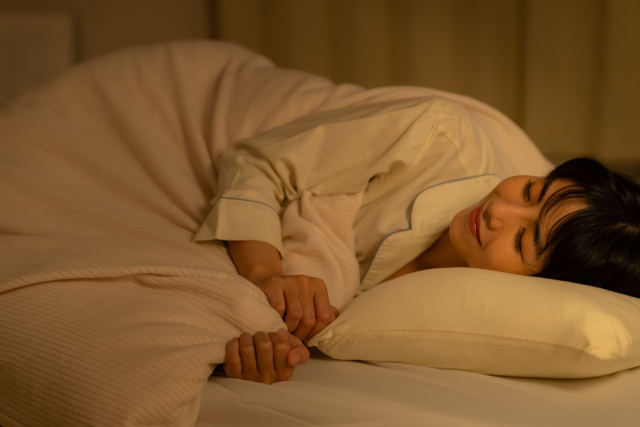 寝室で寝る女性