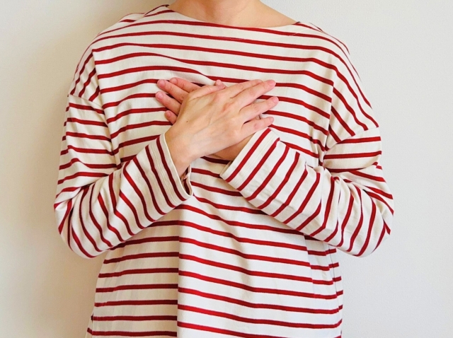 胸に手を当てる女性