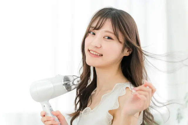 分け目が広がり全体的にボリュームが落ちた女性の髪