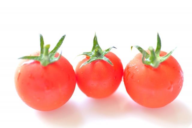 さまざまな形や大きさのトマトが並ぶ写真。人間の頭の形にも個人差があることを、果物の自然なばらつきに例えて表現したイメージ。