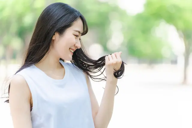 毛髪再生手術を受けた後、自信を取り戻し、自分の髪に満足して微笑む女性のシーン。