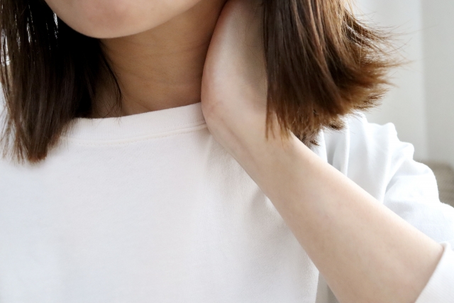 肩までの長さに染めた茶色い髪のカーテンの向こうで、首元に手を添える人物。顔は見えないが、治療後の経過を気にする不安や戸惑いが伝わる。再生植毛後も体が変化に順応し、髪の状態が安定するまでには時間がかかることを示唆するイメージ。