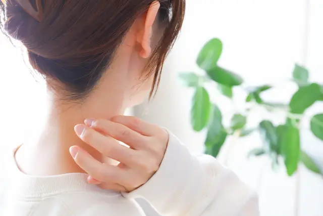 白い袖が手元まで伸び、透けるような指先がそっと首筋の上に浮かぶように見える構図。なめらかでミルクのように明るい素肌が、差し込む陽光の中でやわらかく輝きます。美しいうなじ、透明感ある肌、光に映える女性らしさが印象的な一枚。