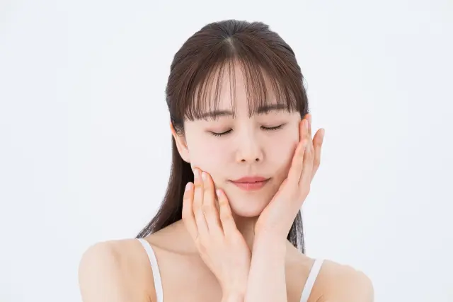 目を閉じた女性が、細い指先で顎のラインをなぞるように顔にそっと触れる瞬間。美しさやヘアケアについて静かに思いを巡らせているような穏やかな表情が印象的。自分と向き合う時間が、内側からの美しさを育む第一歩となることを感じさせる一枚。