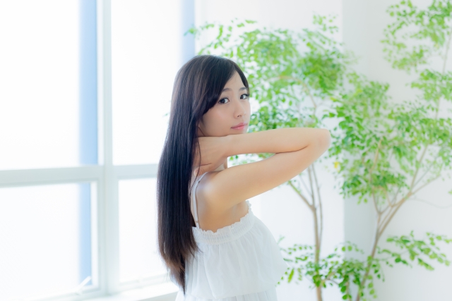 ChatGPT said:
白いキャミソール姿のアジア系女性の横顔。腕を上げて首元に手を添える仕草がナチュラルな美しさを演出し、窓から差し込む光が背中に流れる黒髪をやわらかく照らします。黒髪の艶、素肌の透明感、自然光が映える美しい一瞬。