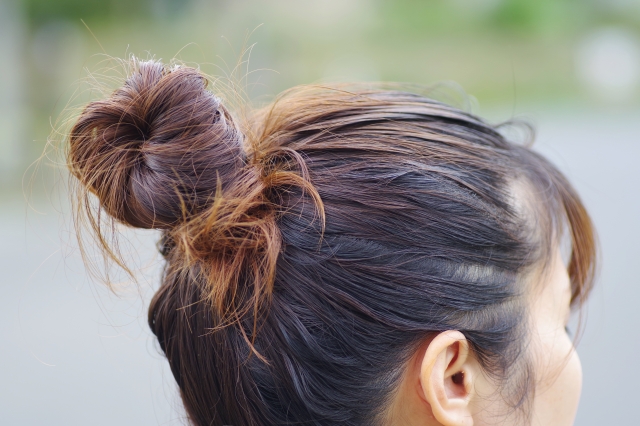 まとめ髪にした女性の後ろ姿。髪の太さや毛流の特徴が分かるシニヨンスタイルは、植毛における美的バランスや自然な仕上がりの参考となるイメージ。