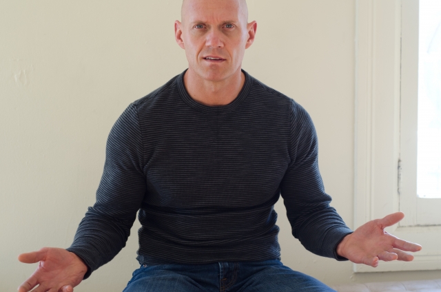 つるつるの頭皮をした男性が椅子に座り、両腕を広げて驚きの表情を浮かべている。目には「本当に髪が生えるのか？」という半信半疑の希望が宿っており、完全に禿げた頭に再び毛髪が戻る可能性を信じたい気持ちが伝わってくる。脱毛に悩んできた男性が、医療による発毛の可能性を初めて知り、戸惑いながらも希望を抱き始めた瞬間を描くイメージ。男性型脱毛症（AGA）の進行後でも発毛治療に望みを持てることを象徴している。