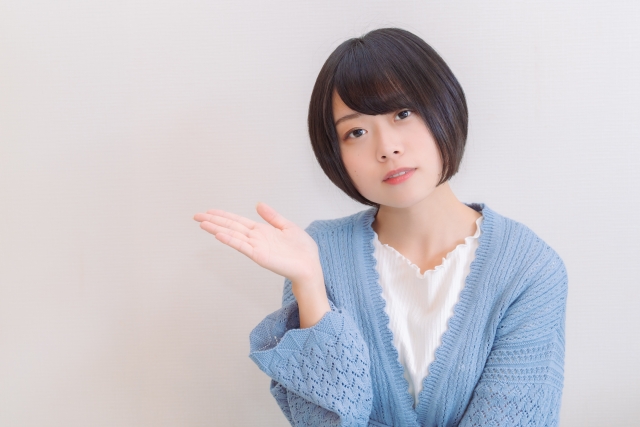 未来の薄毛治療についてスマートに説明するような仕草を見せる若いボブヘアの女性。カメラに向かって右手を上げ、“こんな感じ”と伝えるようなポーズで、幹細胞やPRPなどの新しい治療法の可能性を象徴するイメージ写真。