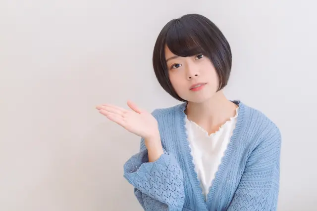 未来の薄毛治療についてスマートに説明するような仕草を見せる若いボブヘアの女性。カメラに向かって右手を上げ、“こんな感じ”と伝えるようなポーズで、幹細胞やPRPなどの新しい治療法の可能性を象徴するイメージ写真。